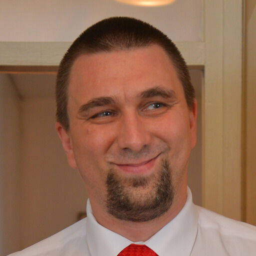 A man with a beard wearing a red tie